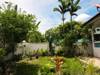 a backyard with a fence and a yard with trees at Cozy House 2BR BTS Ekkamai in Bangkok