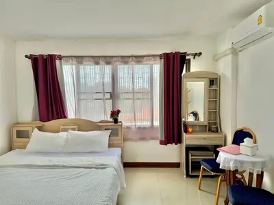 a bedroom with a bed and a window and a table at Baan Alisa 12 in Nonthaburi