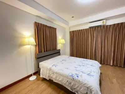 a bedroom with a bed and two lamps and a window at Modern 5-Bedroom Townhome near MRT and Local Charm in Bangkok