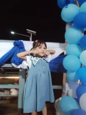 a little girl standing in front of a bed at ร้านพี่บีซ่อมผ้า in Sathani Wat Sing