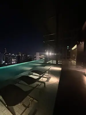 a bench sitting on top of a building at night at 1BR Thonglor BTS InfinityPool overlooking city in Bangkok