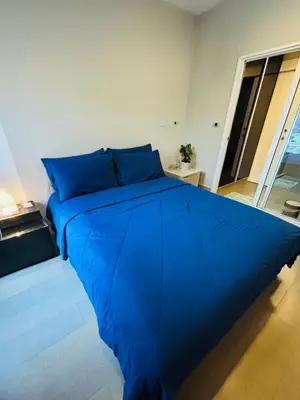 a large blue bed in a white room at 1BR Thonglor BTS InfinityPool overlooking city in Bangkok