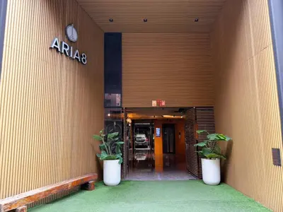 an entrance to an office building with two potted plants at Cozy Mini Theatre - Victory Monument - 3 pax in Bangkok