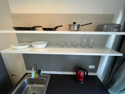a kitchen with a sink and a shelf with dishes at Cozy9Living in Bangkok 60mto MRT in Ban Bang Khwang