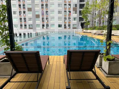 two chairs sitting next to a large swimming pool at Cozy9Living in Bangkok 60mto MRT in Ban Bang Khwang