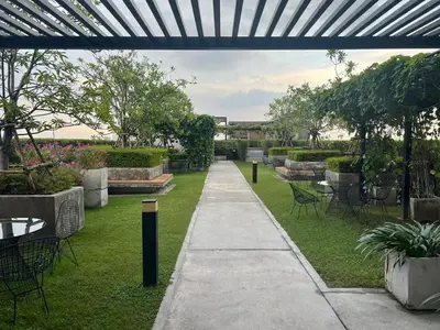 a walkway in a garden with tables and chairs at Cozy9Living in Bangkok 60mto MRT in Ban Bang Khwang