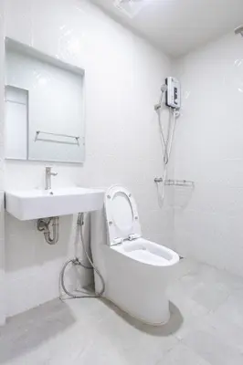 a white bathroom with a toilet and a sink at WJ Luxury Sathorn in Bangkok