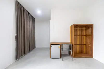 a room with a small refrigerator and a wooden cabinet at WJ Luxury Sathorn in Bangkok