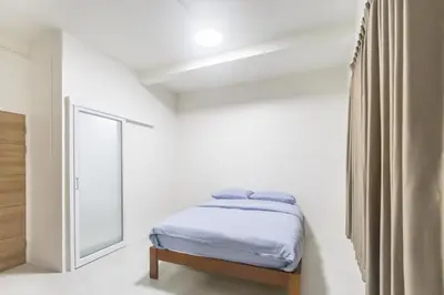 a white bedroom with a bed and a window at WJ Luxury Sathorn in Bangkok
