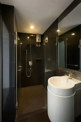 a bathroom with a sink and a glass shower at BTS Thonglor Skyline Condo in Bangkok