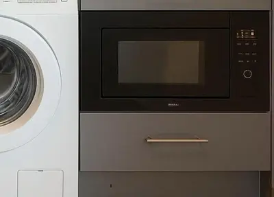 a microwave and a washing machine are next to each other at BTS Thonglor Skyline Condo in Bangkok