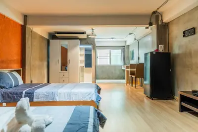 a room with two beds and a table and a kitchen at Five Stars Residence in Bangkok