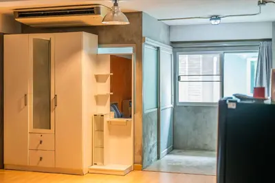 an empty room with a closet and a window at Five Stars Residence in Bangkok
