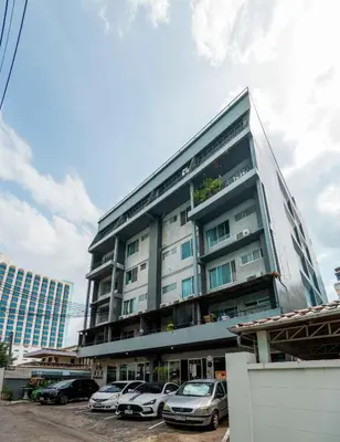 a tall building with cars parked in a parking lot at Five Stars Residence in Bangkok