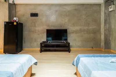 a room with two beds and a flat screen tv at Five Stars Residence in Bangkok
