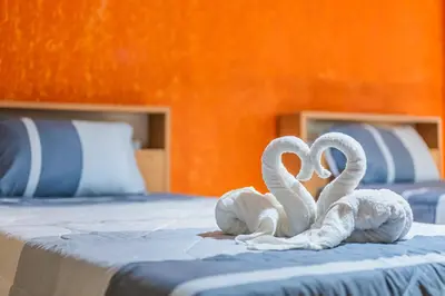 two white swans sitting on top of a bed at Five Stars Residence in Bangkok