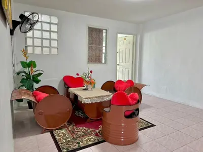 a living room with red chairs and a table at Baan alisa 13 in Nonthaburi