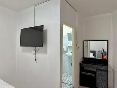 a tv hanging on a wall next to a mirror at Baan alisa 13 in Nonthaburi