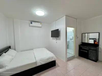 a white bedroom with a bed and a mirror at Baan alisa 13 in Nonthaburi