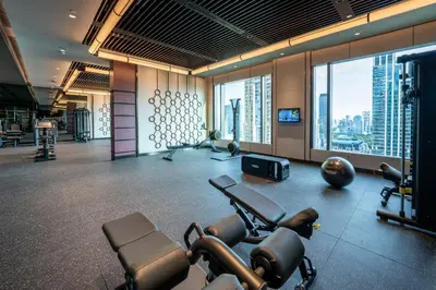 a gym with cardio equipment and a view of a city at Grande Centre Point Prestige Bangkok in Bangkok