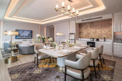 a dining room with a table and chairs and a kitchen at Grande Centre Point Prestige Bangkok in Bangkok