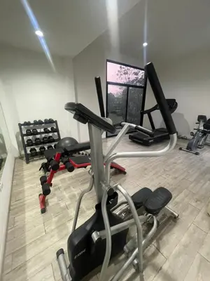 a gym with a treadmill and a computer monitor at Maxim in Pak Kret