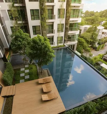 a swimming pool in front of a building at BTS Thong Lor Top Floor City View in Bangkok