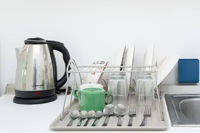 a dish drying rack with a coffee pot and utensils at A space by cream in Bangkok