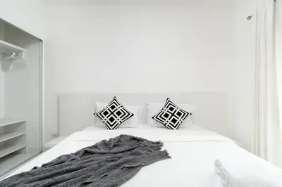 a white bedroom with a bed with a blanket on it at A space by cream in Bangkok