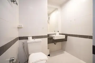 a white bathroom with a toilet and a sink at A space by cream in Bangkok