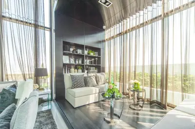 a living room with a white couch and large windows at Knightsbridge Duplex Tiwanon by Natcha in Nonthaburi