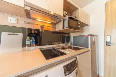 a kitchen with a sink and a stove top oven at Knightsbridge Duplex Tiwanon by Natcha in Nonthaburi