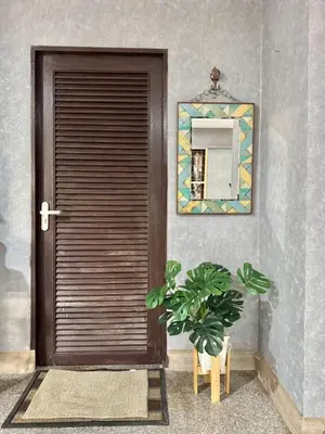a wooden door with a plant next to a mirror at 8Pax Spacious Private Home near The Mall Bangkapi in Ban Bang Toei (1)