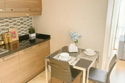 a kitchen with a table with chairs and a tableasteryasteryasteryasteryasteryastery at Cozy stylish home near Nana BTS in Bangkok