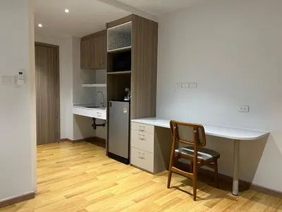 a kitchen with a desk and a chair in a room at Rosewood Sridan in Ban Khlong Samrong