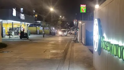 a car driving down a street at night at Rosewood Sridan in Ban Khlong Samrong