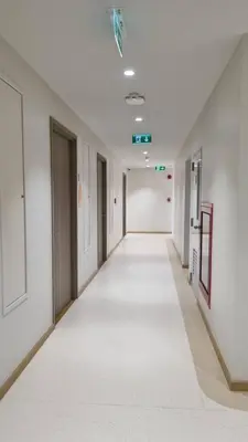 an empty hallway in an office building with white walls at Rosewood Sridan in Ban Khlong Samrong