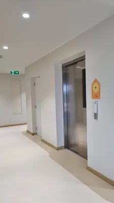 an empty hallway with a metal door in a building at Rosewood Sridan in Ban Khlong Samrong