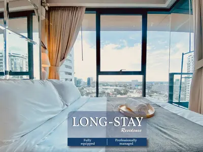 a large bed with a long stay sign in front of a window at River View Modern 1BR - Weekly Cleaning - Phrom Phong in Bangkok