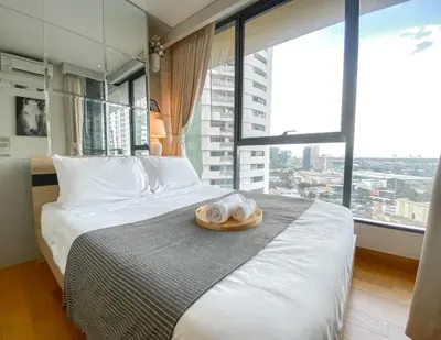 a hotel room with a bed with a hat on it at River View Modern 1BR - Weekly Cleaning - Phrom Phong in Bangkok