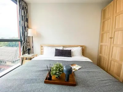 a bedroom with a bed with a plant on a table at Modern-Design Apt 45 sqm - Ultra Fast WiFi - Ekamai in Bangkok