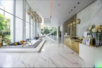 a lobby of a building with marble floors and windows at Hyde Sukhumvit 11 Bankok in Bangkok