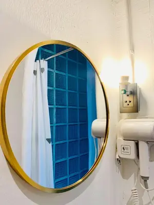 a mirror in a bathroom with a window at Lazy Sunday Khaosan Hotel in Bangkok