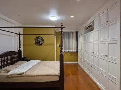 a bedroom with a bed and a yellow wall at The oasis on 8 Villa pool table & KTV in Bangkok