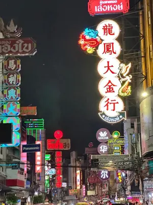 a busy city street at night with neon signs at \u66fc\u8c37\u5510\u4eba\u8857\u4e09\u5c42\u72ec\u680b\u6d0b\u697c24\u5c0f\u65f6\u81ea\u52a9\u5165\u4f4f in Bangkok