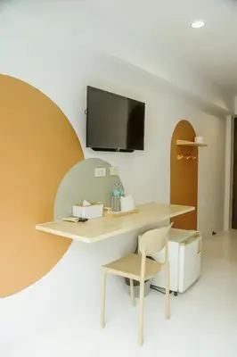 a desk with a chair and a tv on a wall at Full Stop Pool Villa Don Mueang in Lak Si