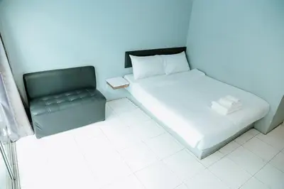 a small bedroom with a bed and a chair at Full Stop Pool Villa Don Mueang in Lak Si