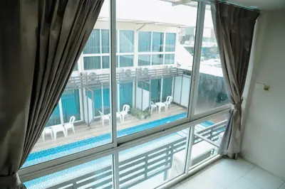 a balcony with a view of a swimming pool seen through a window at Full Stop Pool Villa Don Mueang in Lak Si