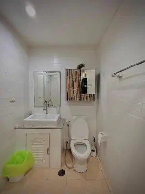 a white bathroom with a toilet and a sink at Stylish Bangkok Condo Furnished, Pool View Prime Location in Bangkok