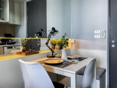 a table with a lamp and chairs in a kitchen at Upscale High-Rise 1BR - Ultra Fast Wifi - Phrom Phong in Bangkok